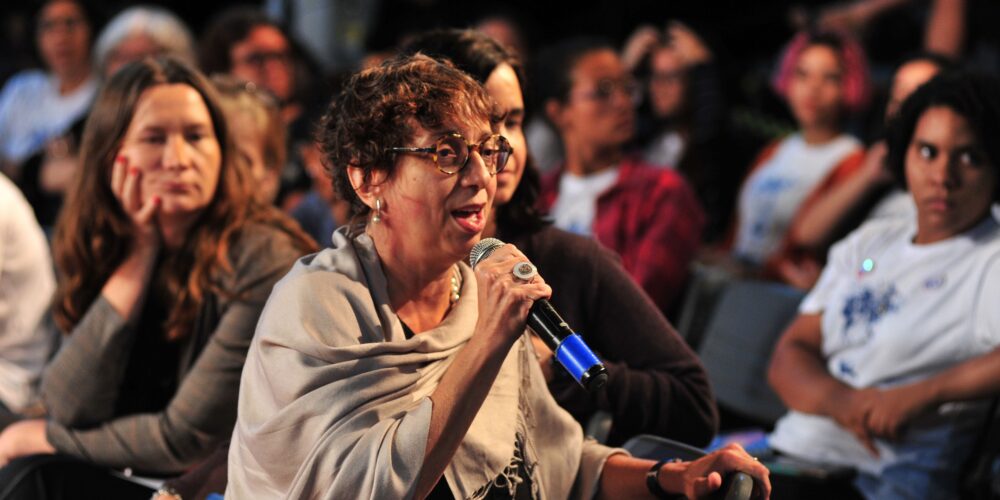 Foto de Auditório com pessoas, divulgação do documentário Ciência Delas