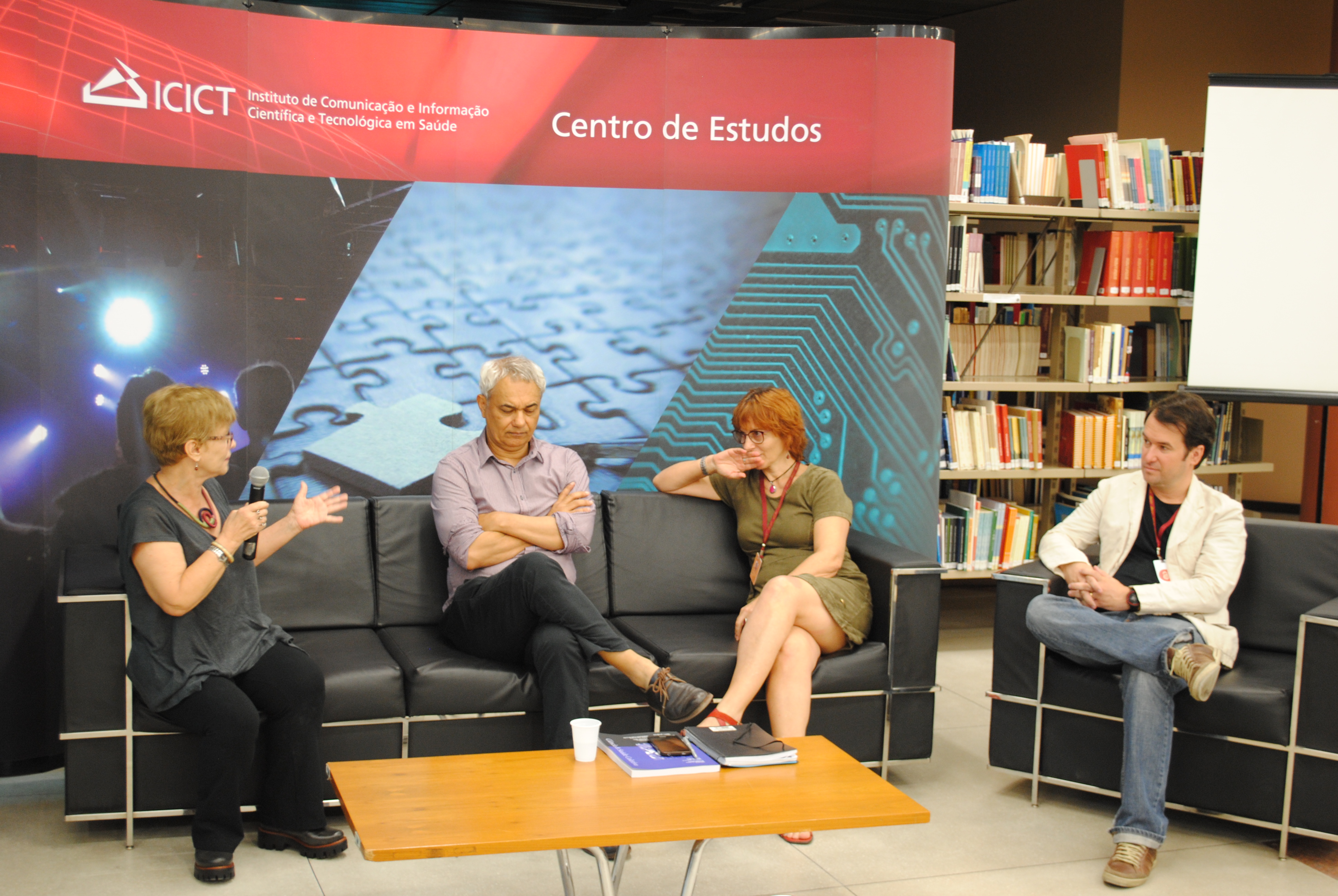 Quatro pesquisadores em debate, sentados no sofá, durante Centro de Estudos, no Salão da Biblioteca de Manguinhos.