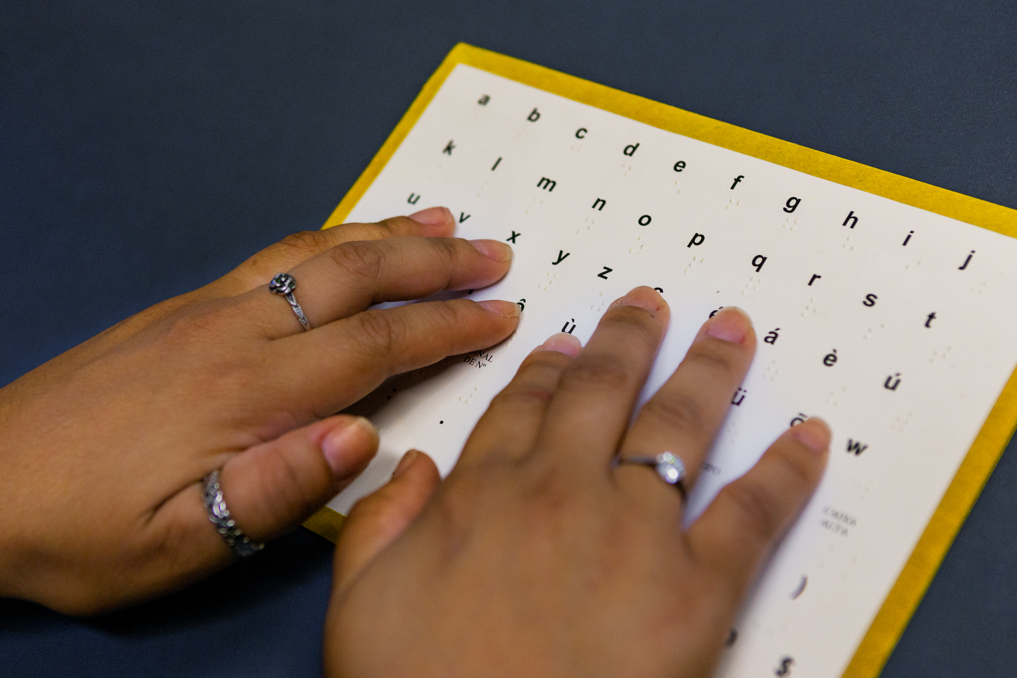 Leitura em Braille. Foto: Raquel Portugal/Fiocruz Imagens. Mãos sobre documento, para leitura em Braille. Foto: Raquel Portugal/Fiocruz Imagens.