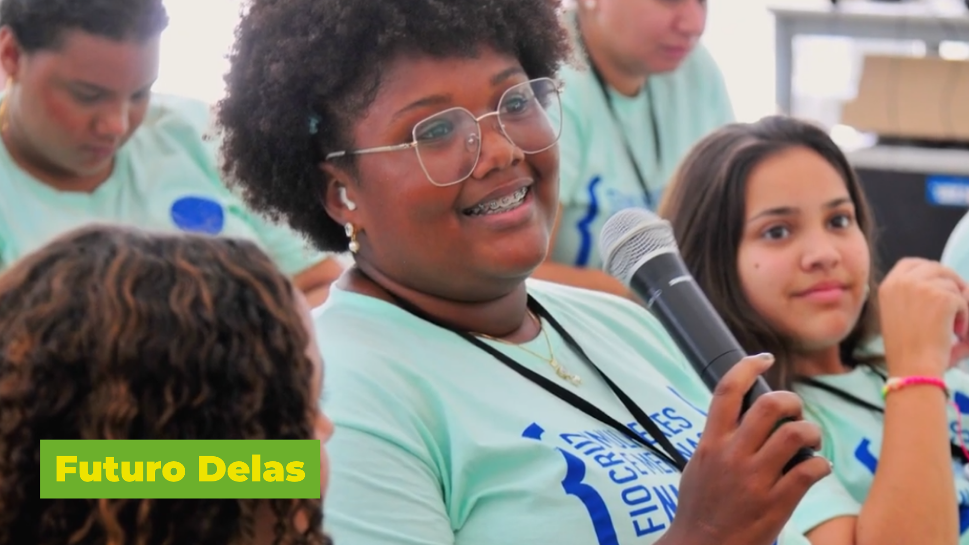 Frame do vídeo Futuro Delas, aparecendo menina com microfone na mão