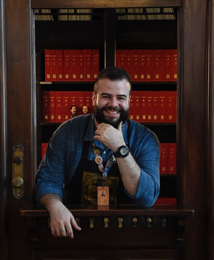 Foto do diretor em uma biblioteca