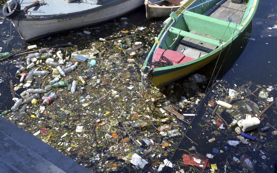 Foto de acúmulo de lixo, ao lado de um barco, na Baía de Guanabara. Foto: Salvador Scofano.