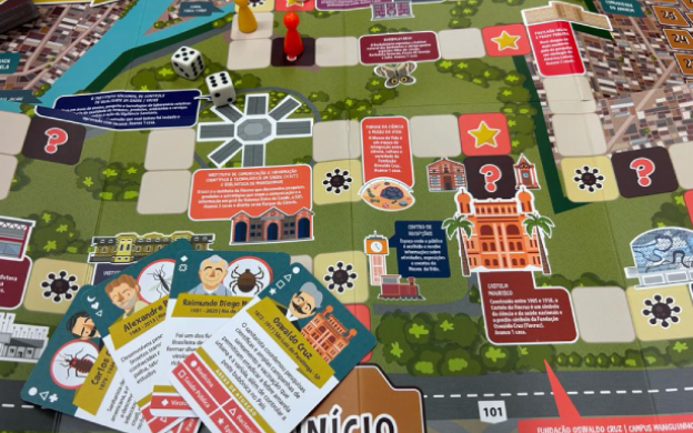 Foto do tabuleiro do jogo Caminhos de Oswaldo com as casas trazendo informações sobre a Fiocruz e cartas sobre pesquisadores.