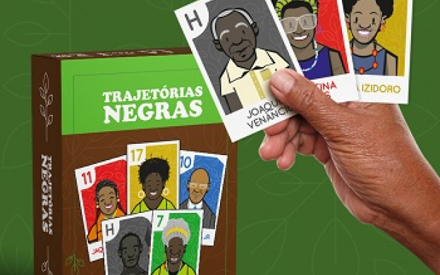Capa do jogo com cartões de celebridades negras em um fundo verde, ao lado de uma mão negra segurando 3 cartas de pessoas negras do jogo.