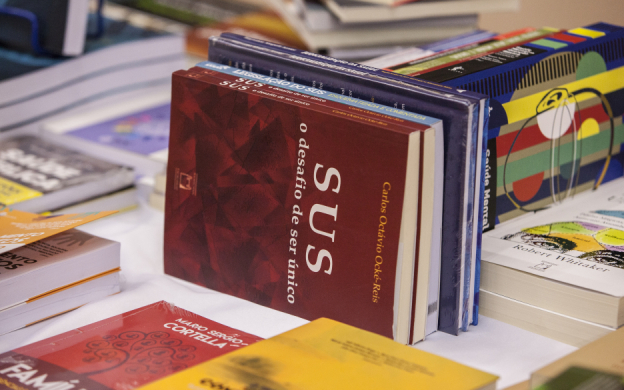 Foto de mesa de livros com destaque para livro sobre o SUS. Foto: Raquel Portugal