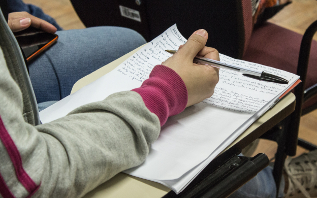 Foto de mão sobre caderno com anotações. Foto: Raquel Portugal