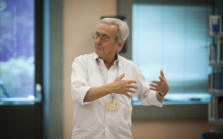 Pesquisador José Noronha, pardo, cabelos grisalhos, camisa branca, em aula do Icict. Foto: divulgação.