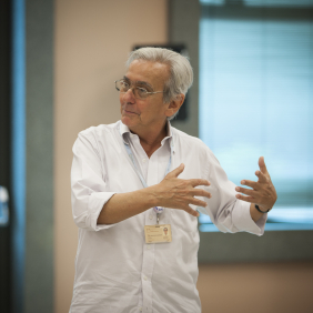 Pesquisador José Noronha, pardo, cabelos grisalhos, camisa branca, em aula do Icict. Foto: divulgação.