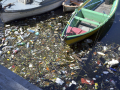 Foto de acúmulo de lixo, ao lado de um barco, na Baía de Guanabara. Foto: Salvador Scofano.