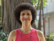 Pesquisadora Irene Kalil, branca, cabelos cacheados pretos, blusa rosa, com árvore ao fundo. Foto: Raquel Portugal/Fioruz Imagens.