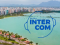 Imagem de divulgação do evento Intercom 2025, com imagem de fundo de Vitória (ES), local do evento