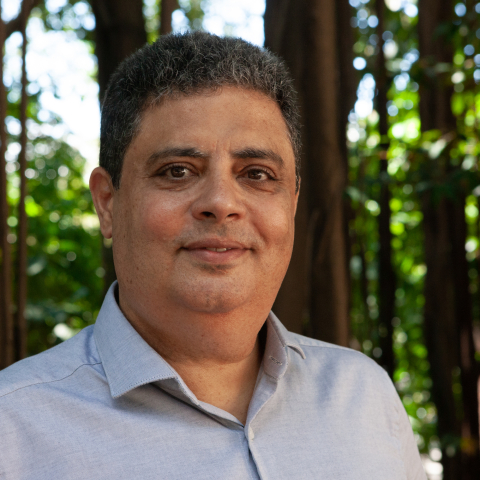 Foto do pesquisador Jefferson Lima, homem branco, cabelos escuros, fundo de natureza, camisa social azul. Foto: Raquel Portugal|Multimeios/Icict.