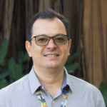 Pesquisador Marcelo, branco, cabelos pretos curtos, camisa social azul e branca