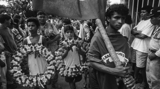 Familiares e militantes carregam a bandeira do MST e guirlandas de flores em uma longa caminhada até o local do enterro, em Curionópolis.