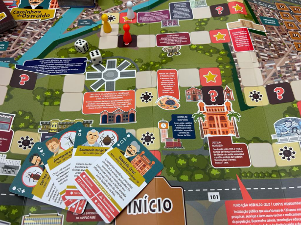 Foto do tabuleiro do jogo Caminhos de Oswaldo com as casas trazendo informações sobre a Fiocruz e cartas sobre pesquisadores.